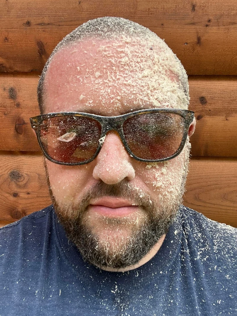 Eric Karlin covered in sawdust after a day of woodworking in the Saw & Cedar shop